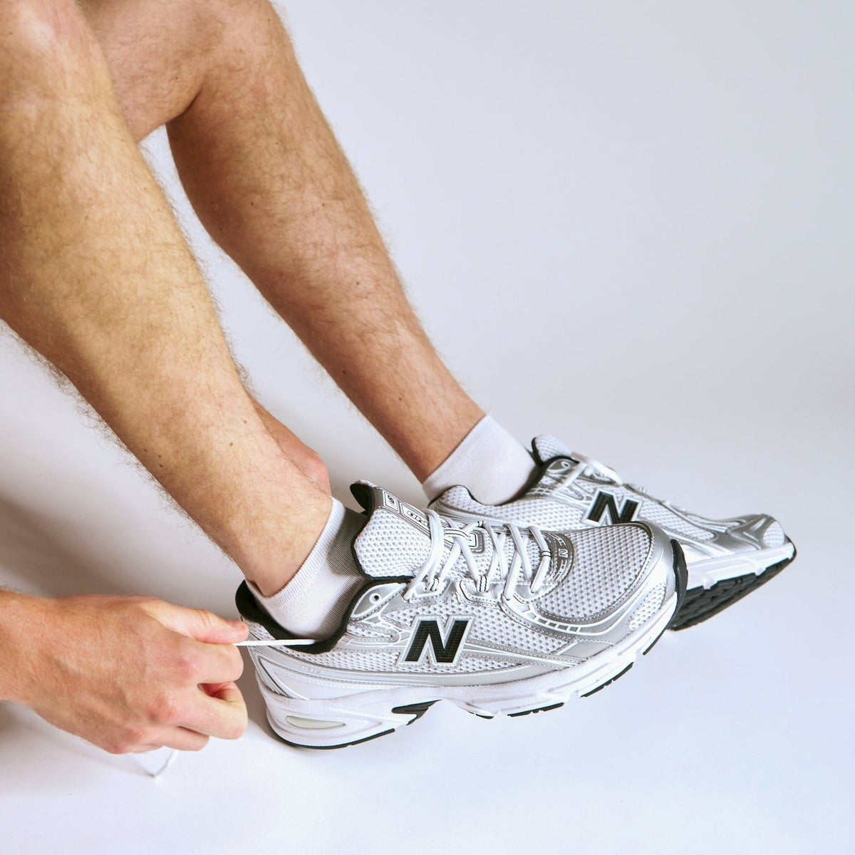 Mann bindet seine Sneaker, Bambus-Socken am Fuß